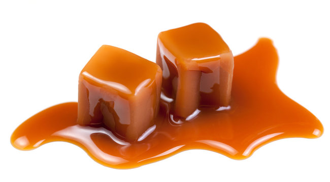 Sweet Caramel candies with caramel topping  sauce isolated on a white background close up.