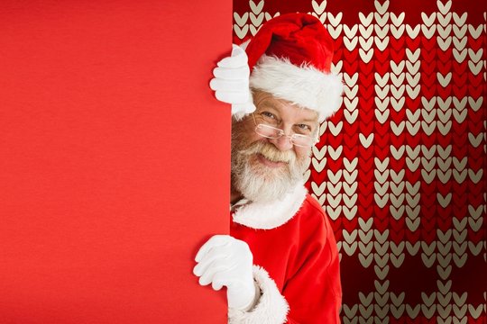 Composite image of santa claus peeking from red board - Powered by Adobe