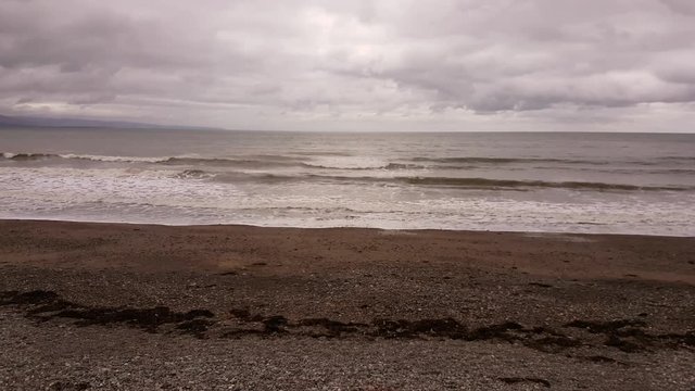 Looking out to sea, the waves lapping on Criccieth beach.