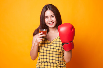 Young Asian woman with tomato juice and boxing glove.