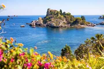 Isola Bella from Taormina in Sicily with a beautiful flower frame at the bottom - obrazy, fototapety, plakaty