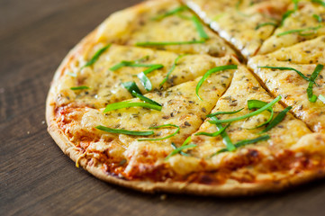 sliced Pizza Margherita or Margarita with Mozzarella cheese. Italian pizza on wooden background
