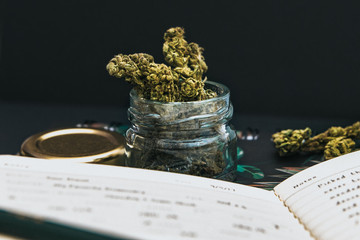 Close up cannabis buds in a jar, stationery and black background