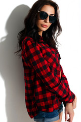 Naklejka premium Brunette model, fashion model on a white background, model in a plaid shirt