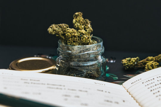 Close up cannabis buds in a jar, stationery and black background