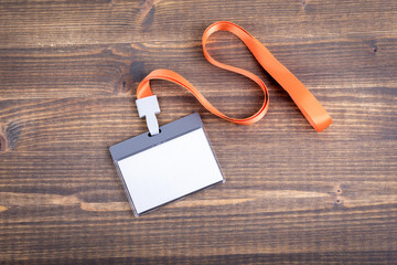 White empty staff identity mockup with orange lanyard. Name tag, ID card. Wood texture background