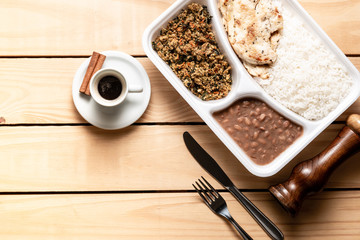 white rice chicken beans and manioc flour. Brazilian lunch box. top view