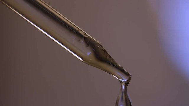 Loop of Slow motion, liquid drips from dropper close up