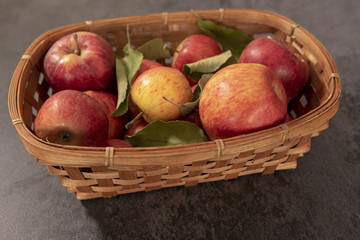 A basket of red apples on a black background 