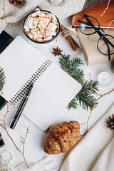 Winter Flat Lay . Hot chocolate or cocoa with marshmallow , cookies, notebook and tartan textured sweater on with  on white background.