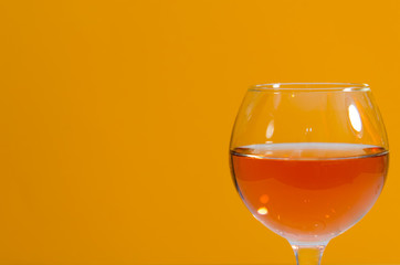 Glass of rose wine on orange background
