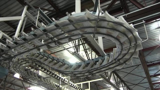 Loop of Newspapers flow along an assembly line in a newspaper factory.