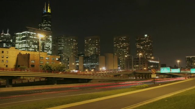 Loop of Traffic passes along a city freeway at night.