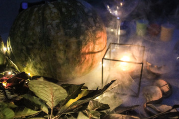 Night Helloween composition with pumpkin,leavesand candles.Warm and cold light.Garland.