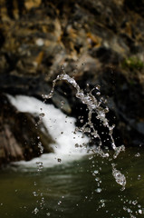 Water splash with blurry waterfall on the background