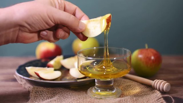 man dipping an apple in honey