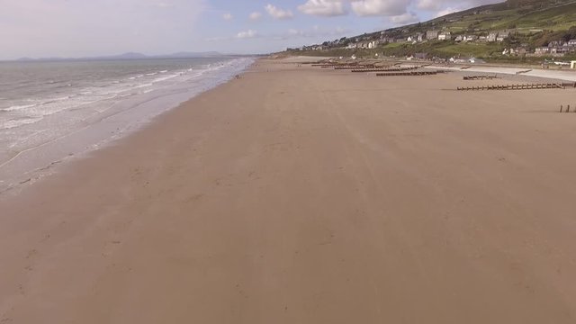 Aerial footage flying backwards over Barmouth beach.