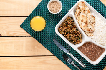 white rice chicken beans and manioc flour. Brazilian lunch box. top view