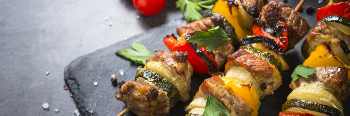 Grilled shish kebab with vegetables  on black.