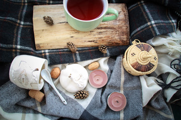 Autumn atmospheric composition of the home layout.Box from the vines, bumps, candles, cup of tea, autumn decor, wooden board and textiles.