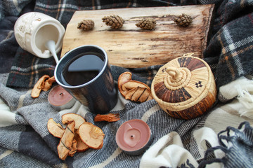 Autumn atmospheric composition of the home layout.Box from the vines, bumps, candles, cup of tea, autumn decor, wooden board and textiles.