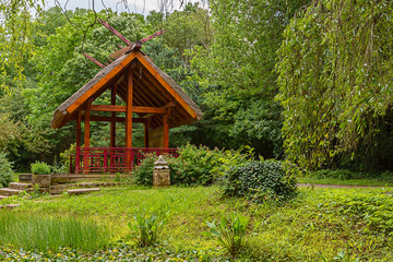 Shelter, wooden gazebo in the park and green grass