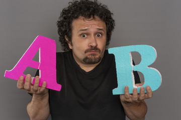 Optimize, conversion funnel, A / B test in marketing and online advertising. Brunette man holding colored letters A and B in hands with face expressions