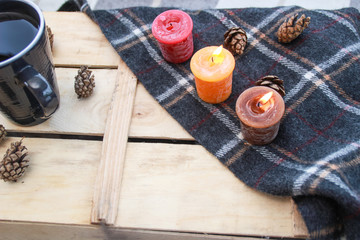 Autumn atmospheric composition of the home layout.Box from the vines, bumps, candles, cup of tea, autumn decor, wooden board and textiles.
