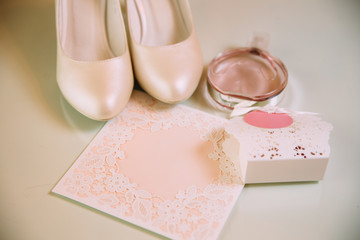 Flatley photo beige sandals, tender bridal bridal bouquet, hair decorations are laid out on a light insulated surface. Copyspace.