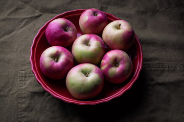 Apples in a pie dish on a green cloth