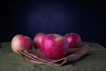 Red apples on a brown paper bag and green cloth