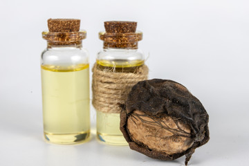 Oil in a bottle and walnuts on a white kitchen table. Spices and ingredients useful in kuchi.