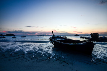 Sunrise with a boat on the sand in a beach, Koh Lipe, Thailand