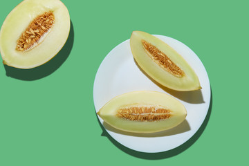 Melon sliced on bright green background. Minimal fruit concept.