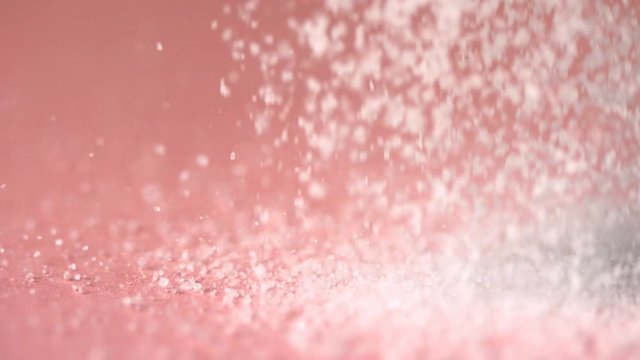 Loop of Sugar falling onto pink surface