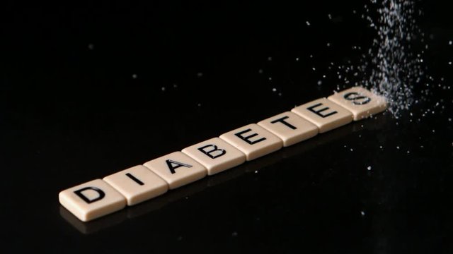 Loop of Sugar pouring over letter pieces spelling diabetes