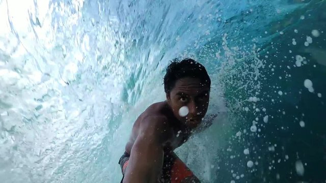 Loop of SLOW MOTION: Extreme pro surfer surfing big tube barrel wave