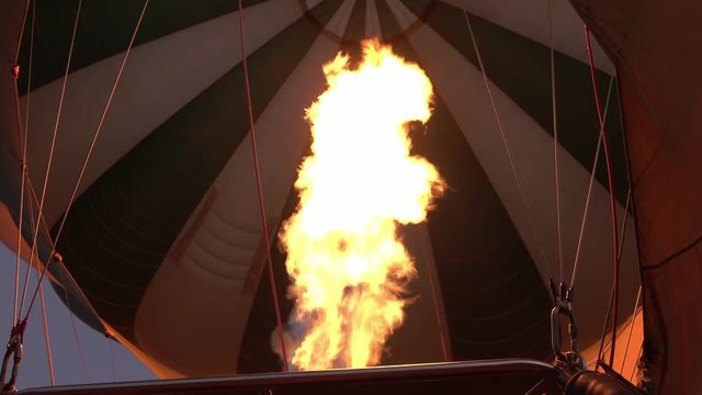 Loop of CLOSE UP: Pilot inflates safari balloon with hot air by activating the burners