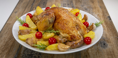 Roast chicken and various vegetables on a white plate