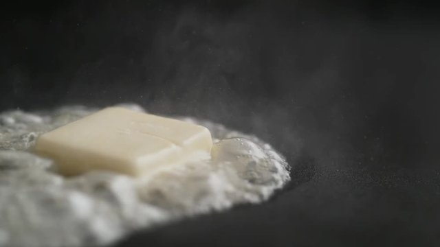 Loop of Butter melting on heated non stick pan. Shot with high speed camera, phantom flex 4K. Slow Motion.