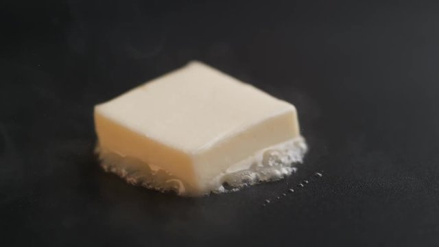 Loop of Butter melting on heated non stick pan. Shot with high speed camera, phantom flex 4K. Slow Motion.