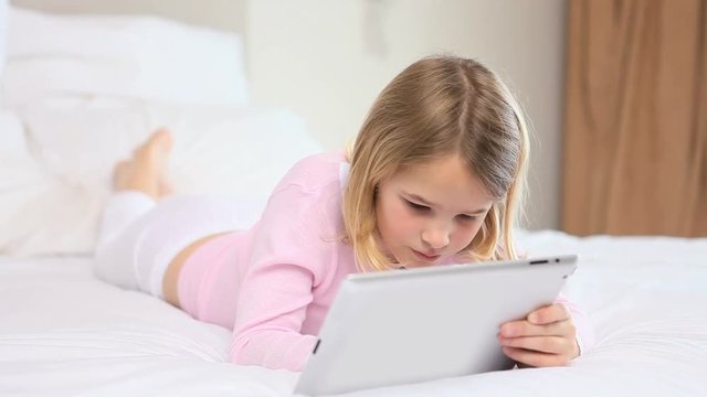 Loop of Blonde girl using a tablet computer