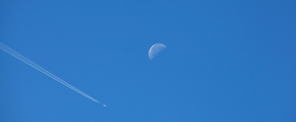 Trainées d'avions dans le ciel avec la lune