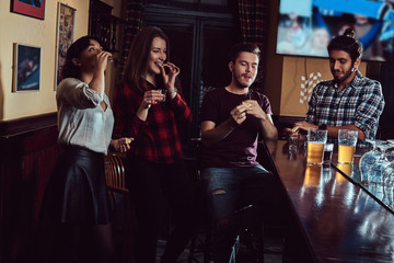 Group of multiracial friends resting and talking at the bar or pub.