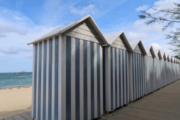 Cabines de plage à rayures bleues et blanches alignées à Carantec, en Bretagne (France)