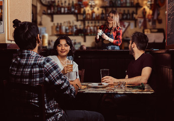 Young multiracial friends resting in the pub.