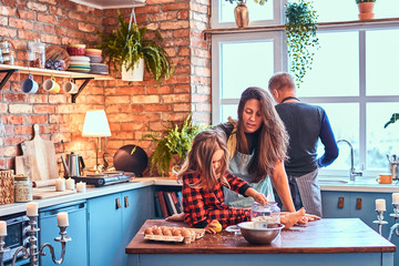 Family together cooking breakfast in loft style kitchen.