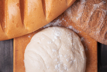 Dough and bread on wooden background, top view, fresh pastry concept.