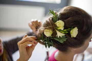 Naklejka premium preparing hairstyles with flowers, wedding hairstyle, hairstyle with flowers, hairstyle with roses