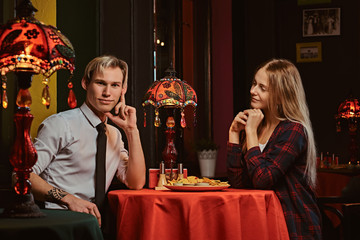 Attractive couple eating nachos during dating at Mexican restaurant. 